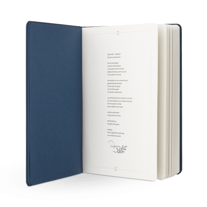 An open navy blue hardcover Brave Tinctures Trio Set by Ancient + Brave is displayed with a printed poem on cream-colored pages, featuring a small decorative leaf illustration beneath the text. The white background evokes an atmosphere of clarity and calm.
