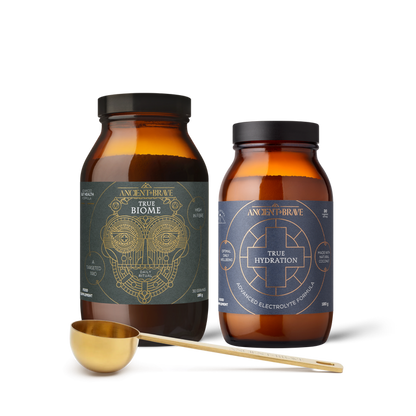 Two bottles of 'True Biome' and 'True Hydration' with a gold scoop on a white background