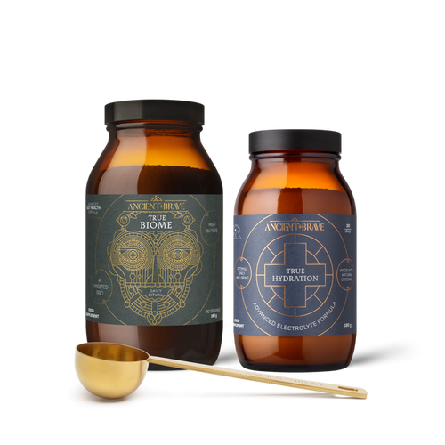 Two bottles of 'True Biome' and 'True Hydration' with a gold scoop on a white background