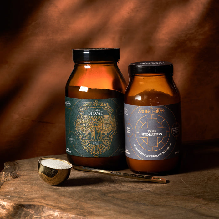 Two amber glass jars with labels on a wooden surface with a warm brown background