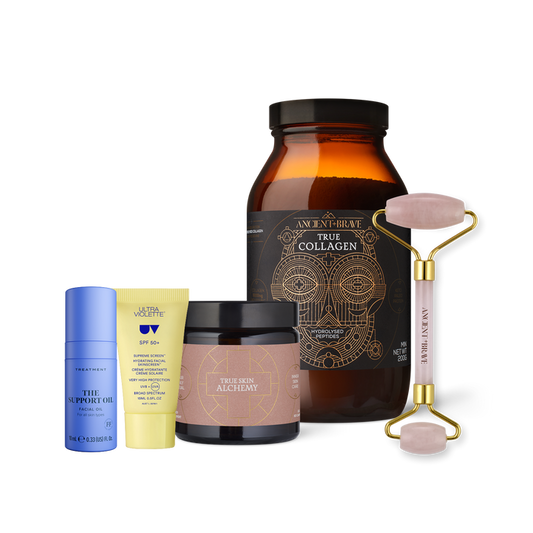 Ancient + Brave’s The Skin Essentials Kit features a curated selection of skincare essentials for radiant-looking skin—including a brown collagen jar, a black and gold alchemy jar, a blue bottle, a yellow tube for daily SPF protection, and a pink facial roller—beautifully arranged against a white background.