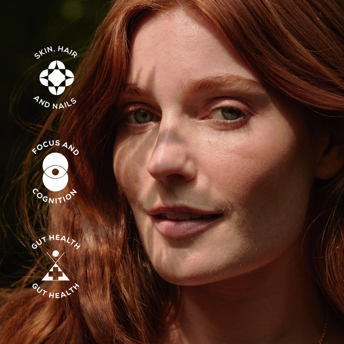 Close-up of a person with red hair and logos with text about skin, hair, nails, focus, cognition, and gut health.