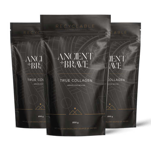 Three stand-up pouches of Ancient + Brave's True Collagen powder arranged in a fan shape against a solid black background. The packaging is dark grey with white text and gold accents.