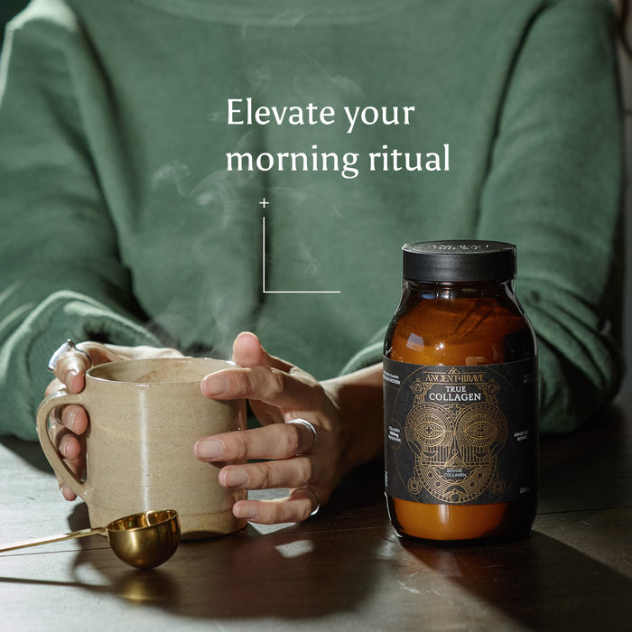 A person in a green sweater holds a steaming mug next to a jar of Ancient + Brave True Collagen, with a gold spoon resting on the table. Text reads: Elevate your morning ritual—with hydrolysed bovine collagen for daily wellness.