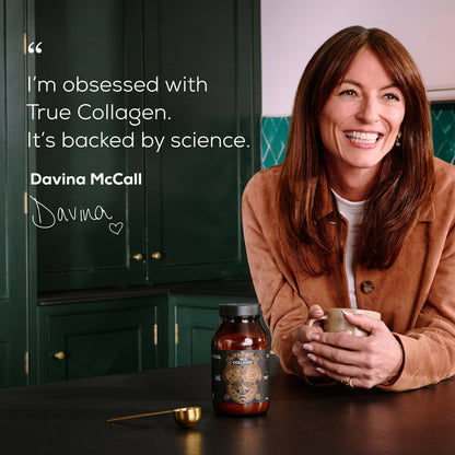 A smiling woman in a brown jacket leans on a kitchen counter, holding a cup. On the counter are a jar labeled Ancient + Brave True Collagen Sachets—premium bovine collagen powder—and a golden spoon. Text quotes her endorsement of the product, highlighting its anti-ageing benefits.