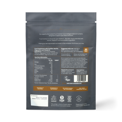 The back of a True Creatine+ black pouch displays white and orange text with nutritional info, suggested use, ingredients for muscle and cognitive health, certifications, branding, and several icons and logos at the bottom.
